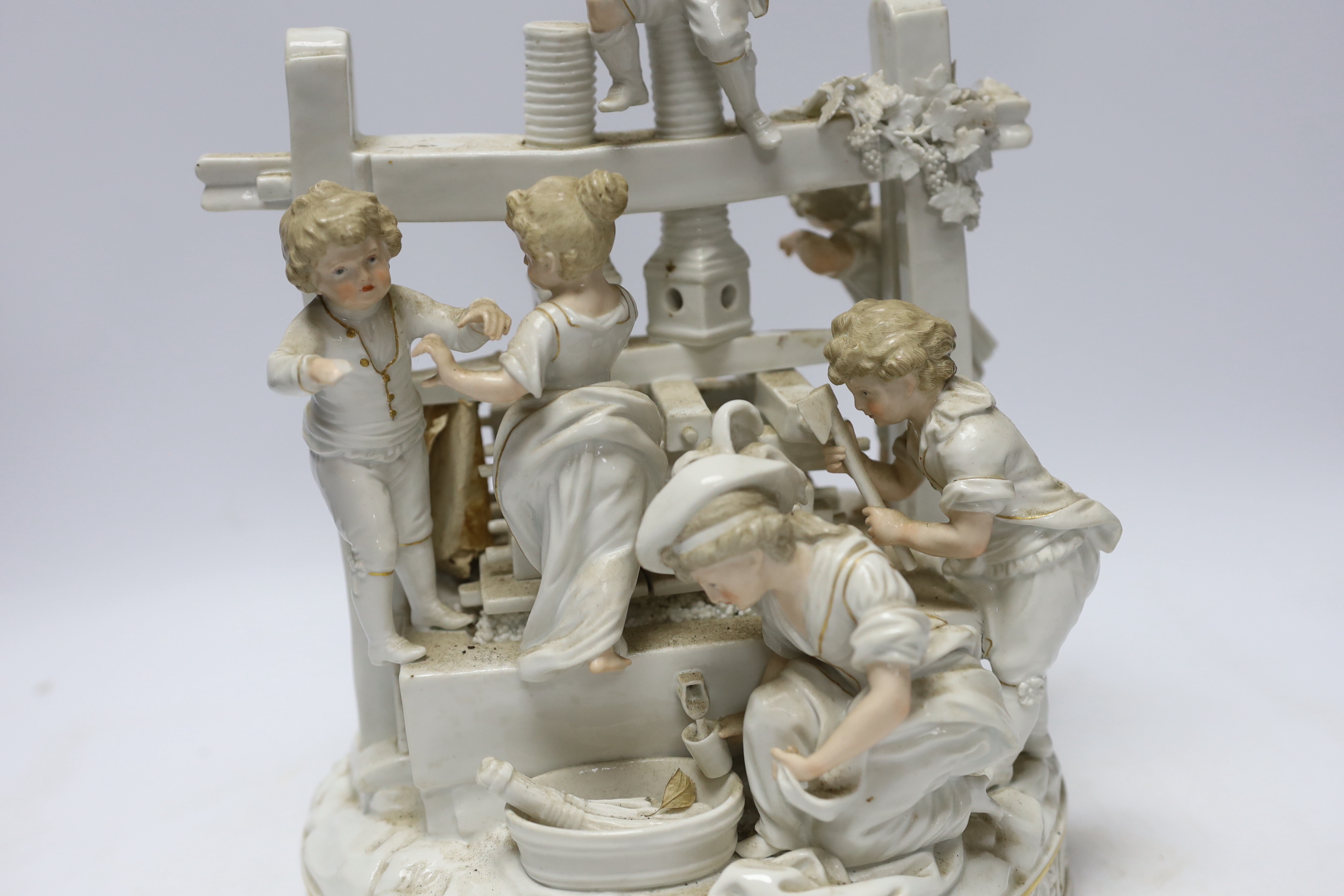 A late 19th century German white glazed porcelain group, ‘’The Wine Press’’, after a Meissen original by Johann Carl Schonheit, 33cm